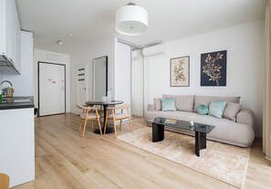 A modern living room with a sofa, coffee table, and dining area. - Browary Warszawskie Boutique Studio (Warszawa)