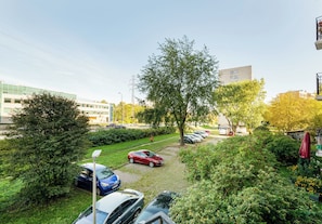 Ein Parkplatz mit Autos, einem Fußweg und Grünflächen.