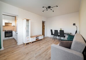 A modern living space with a kitchen, dining area, and seating. - Mokotów Rzymowskiego Urban Apartment (Warszawa)