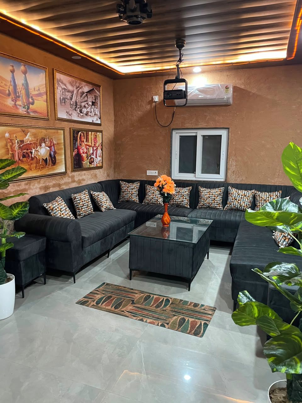A living room with a sectional sofa, a glass coffee table, and a patterned rug.