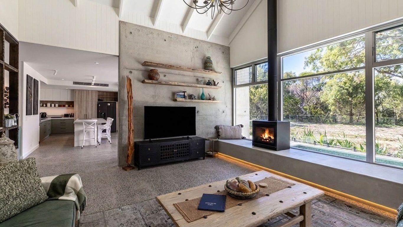 A living room with a fireplace, a television, and a dining area with a table and chairs.
