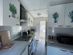 Una cocina moderna con horno integrado, microondas y tostadora.
