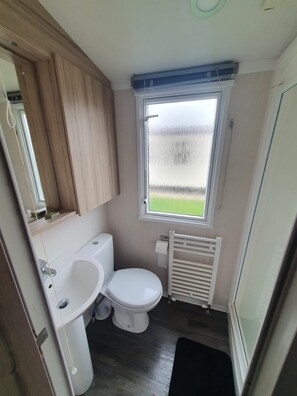 Un baño pequeño con inodoro, lavabo y ventana.