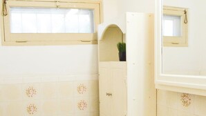 A bathroom with a toilet, sink, and mirror. - Playa Plateada Beach House (Ensenada)