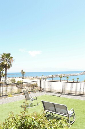 A patio with two metal chairs and a view of the ocean. - Playa Plateada Beach House (Ensenada)
