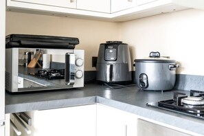A kitchen with a microwave, air fryer, and slow cooker on the counter. - GuestReady - Modern & Stylish 1bed in Battersea (London)