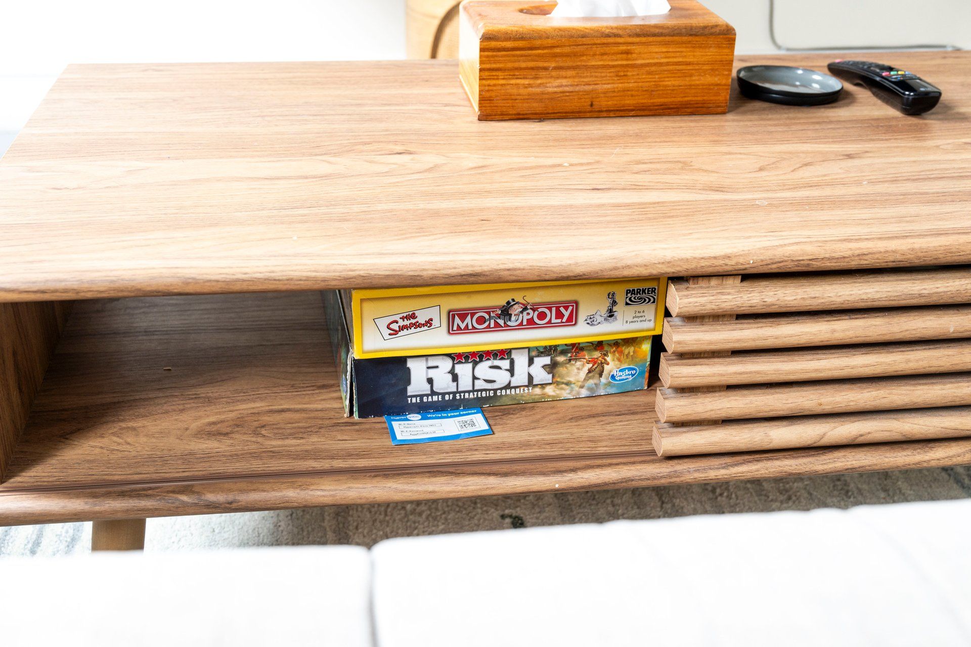 A wooden table with a Monopoly board game partially visible underneath.