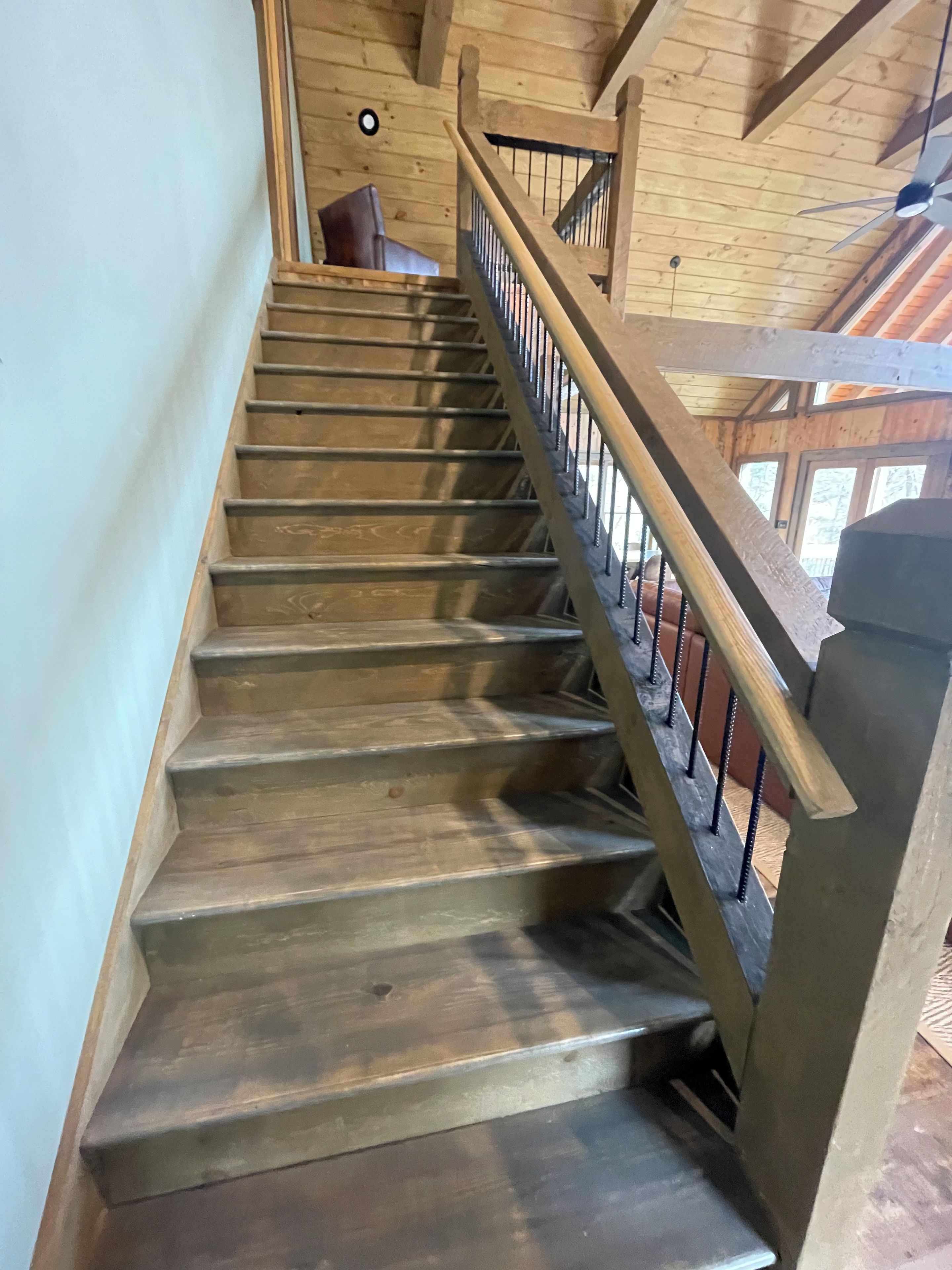 A wooden staircase with metal railings leading to an upper level.