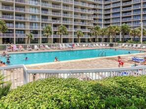 A hotel pool area with multiple levels of balconies, lounge chairs, and a clear blue pool. - Emerald Views, ` (Orange Beach)