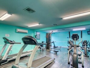 A gym with treadmills, elliptical machines, and weight equipment. - Emerald Views, ` (Orange Beach)