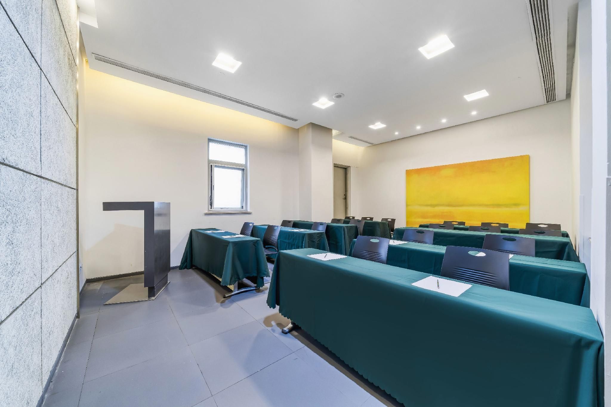 A conference room with tables, chairs, a podium, and a large window.