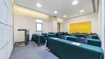 A conference room with tables, chairs, a podium, and a large window.