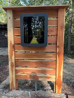 A wooden structure with a warning sign for electrical danger.