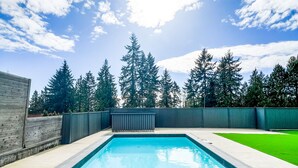 Una piscina rettangolare con bordo piastrellato, circondata da un solarium in cemento.