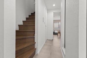 Eine Treppe führt zu einem Schlafzimmer mit einem Bett und einem kleinen Tisch.