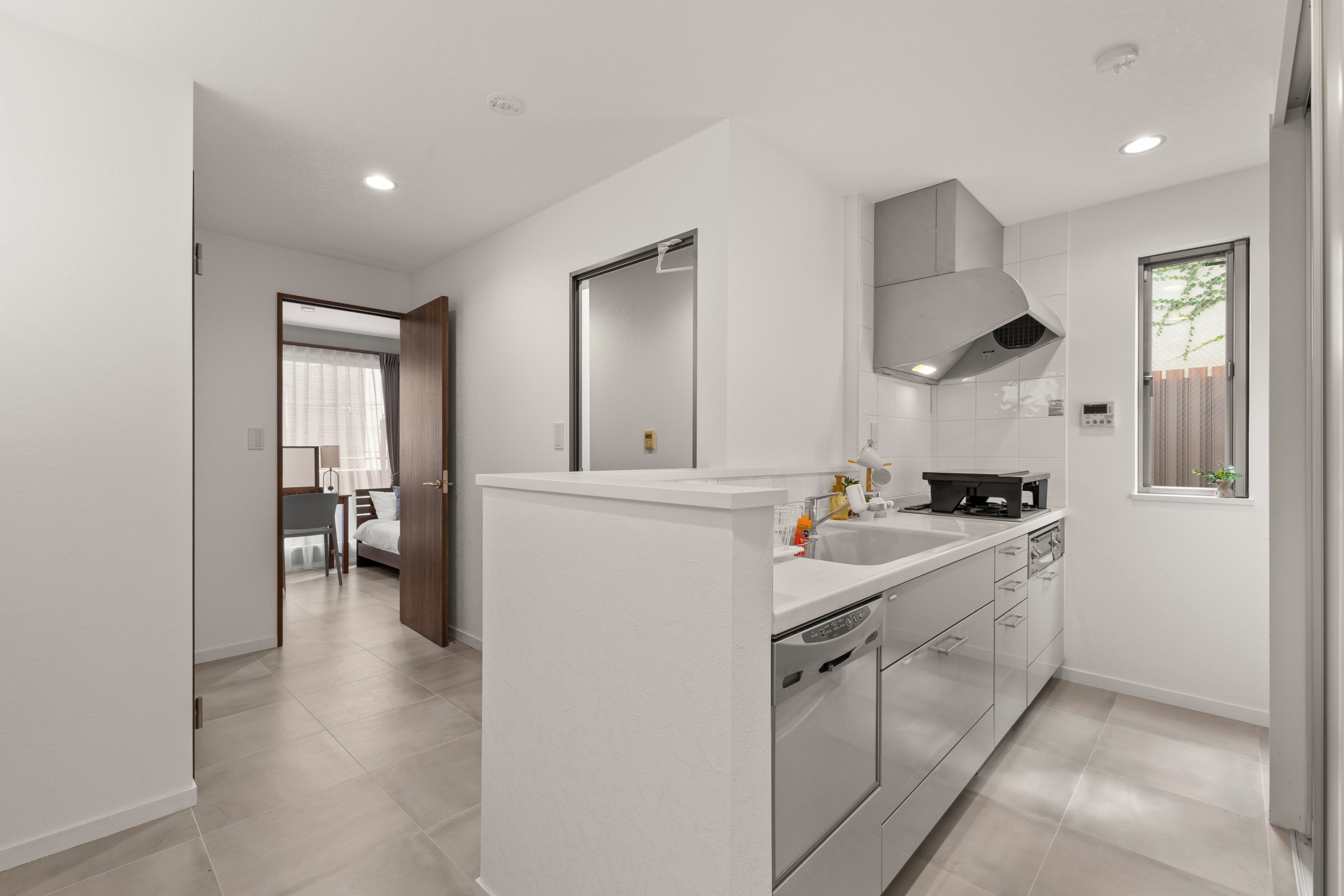 A modern kitchen with a central island, stainless steel appliances, and a window with a view.