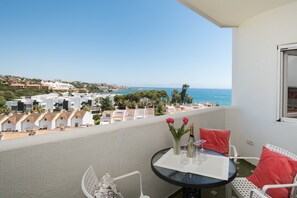 A balcony with a table, chairs, and a view of the sea and buildings. - Selecta Estepona Sunrise (Estepona)