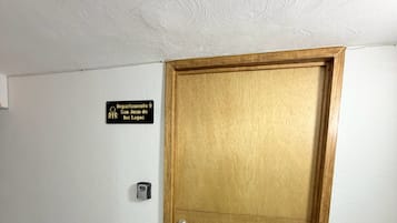 Una puerta de madera cerrada con un letrero encima que dice 'Departamento 9 San Juan de los Lagos'.