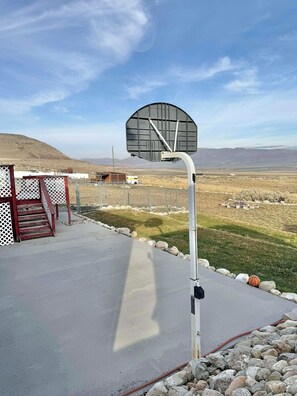 An outdoor basketball court with a hoop, a staircase, and a view of the surrounding landscape. - 3-bedroom apartment in peaceful Tremonton (Tremonton)