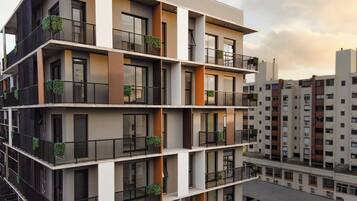 Um edifício residencial de vários andares com varandas, janelas amplas e um design arquitetônico moderno.
