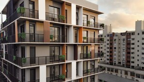 Um edifício residencial de vários andares com varandas, janelas amplas e um design arquitetônico moderno.