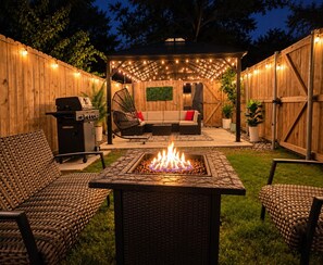 An outdoor patio with a fire pit, seating, and a barbecue grill. - Dallas–McKinney Modern Retreat  5BR • Games • EV Charging (McKinney)