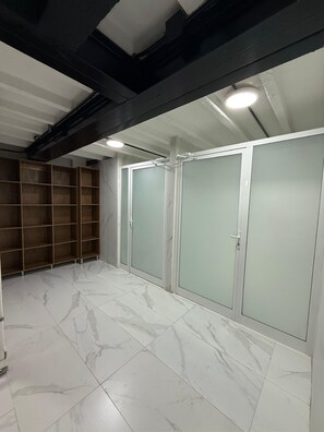 Una habitación con piso de mármol, una estantería de madera y un conjunto de puertas corredizas.