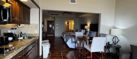 A kitchen with a dining area, a ceiling fan, and a tiled floor.