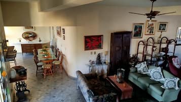Amplia sala de estar con mesa de comedor, sofá y ventilador de techo.