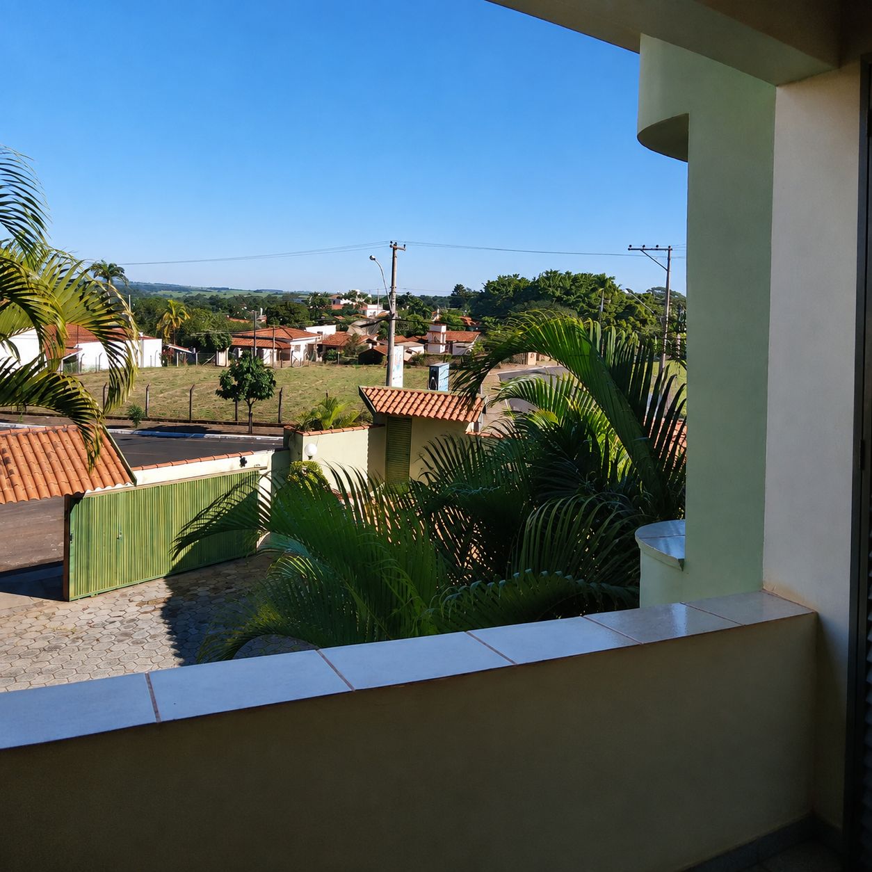 Un quartiere residenziale con case, cielo sereno e qualche spazio verde.