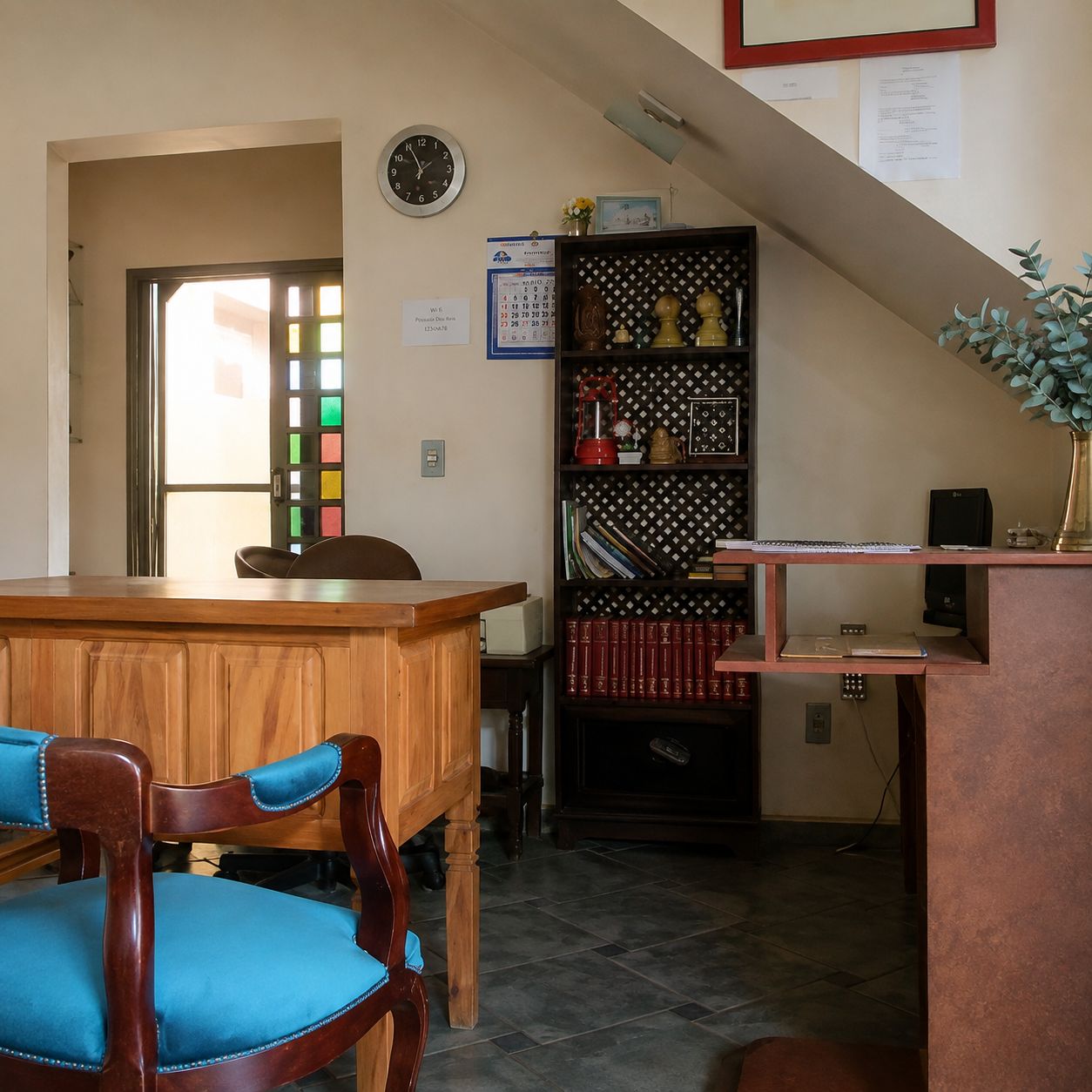 A room with a wooden desk, a chair, a bookshelf, and a clock on the wall.