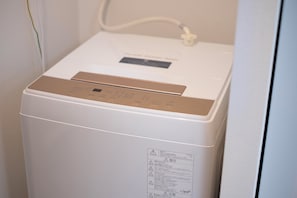 Ein weißer Warmwasserbereiter mit Bedienfeld und Warnhinweis.