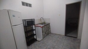 A compact kitchen with a refrigerator, microwave, and a small sink.