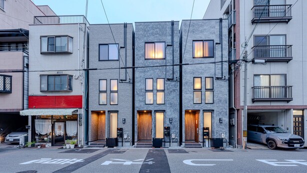 A row of modern buildings with a flat facade, multiple windows, and a visible entrance with a door. - NIKYO YAMA  Villa Osaka (Osaka city ,Konkhana-ku)