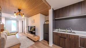 A modern kitchen with wooden cabinets, a built-in oven, and a sink. - NIKYO YAMA  Villa Osaka (Osaka city ,Konkhana-ku)
