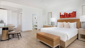 A hotel room with a bed, bedside tables, a desk, and a chair. - Oceanfront 2BR on Grace Bay at Alexandra Resort 2nd fl 1,384 Sq Ft (The Bight Settlement)