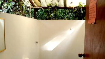 A small bathroom with a toilet, sink, and green tiled floor.