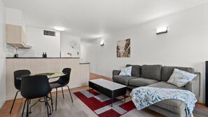 Un espacio habitable compacto con kitchenette, comedor y zona de estar.