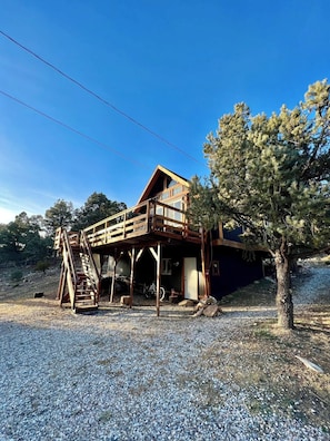 A wooden cabin with a deck and a staircase leading to a second level. - ¡De bienvenida! Chalet “Ojo en el cielo”. (Big Bear)