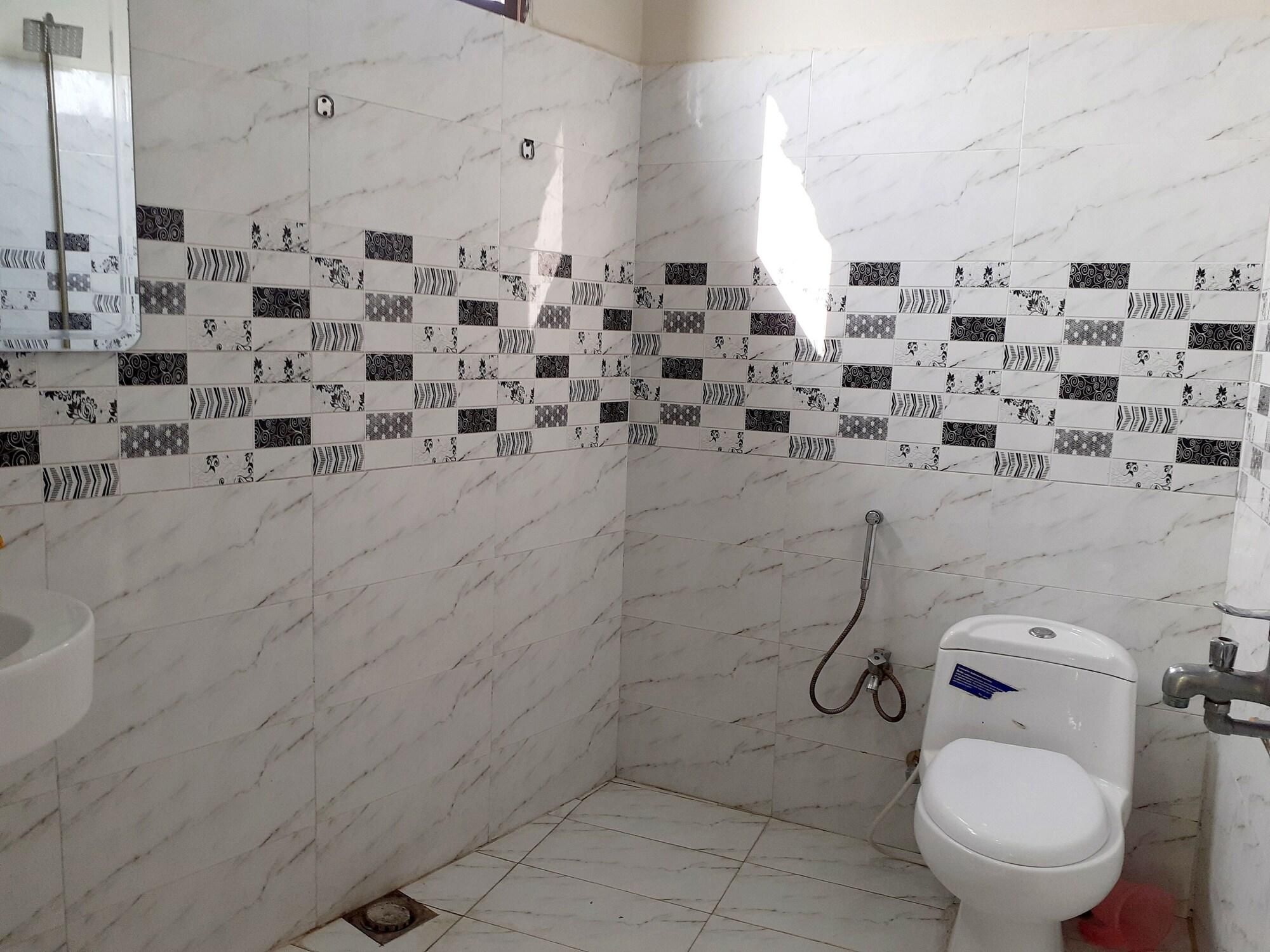 Un baño con inodoro, ducha y lavamanos.