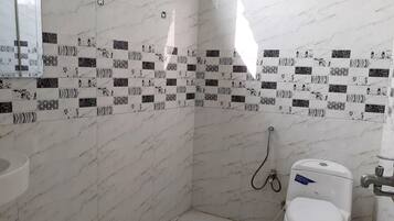 Un baño con inodoro, ducha y lavamanos.