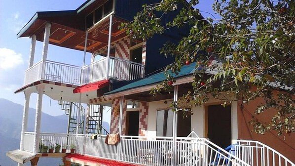 A multi-story building with balconies, a staircase, and a view of the mountains. - Bhurban Apartments (Bhurban)