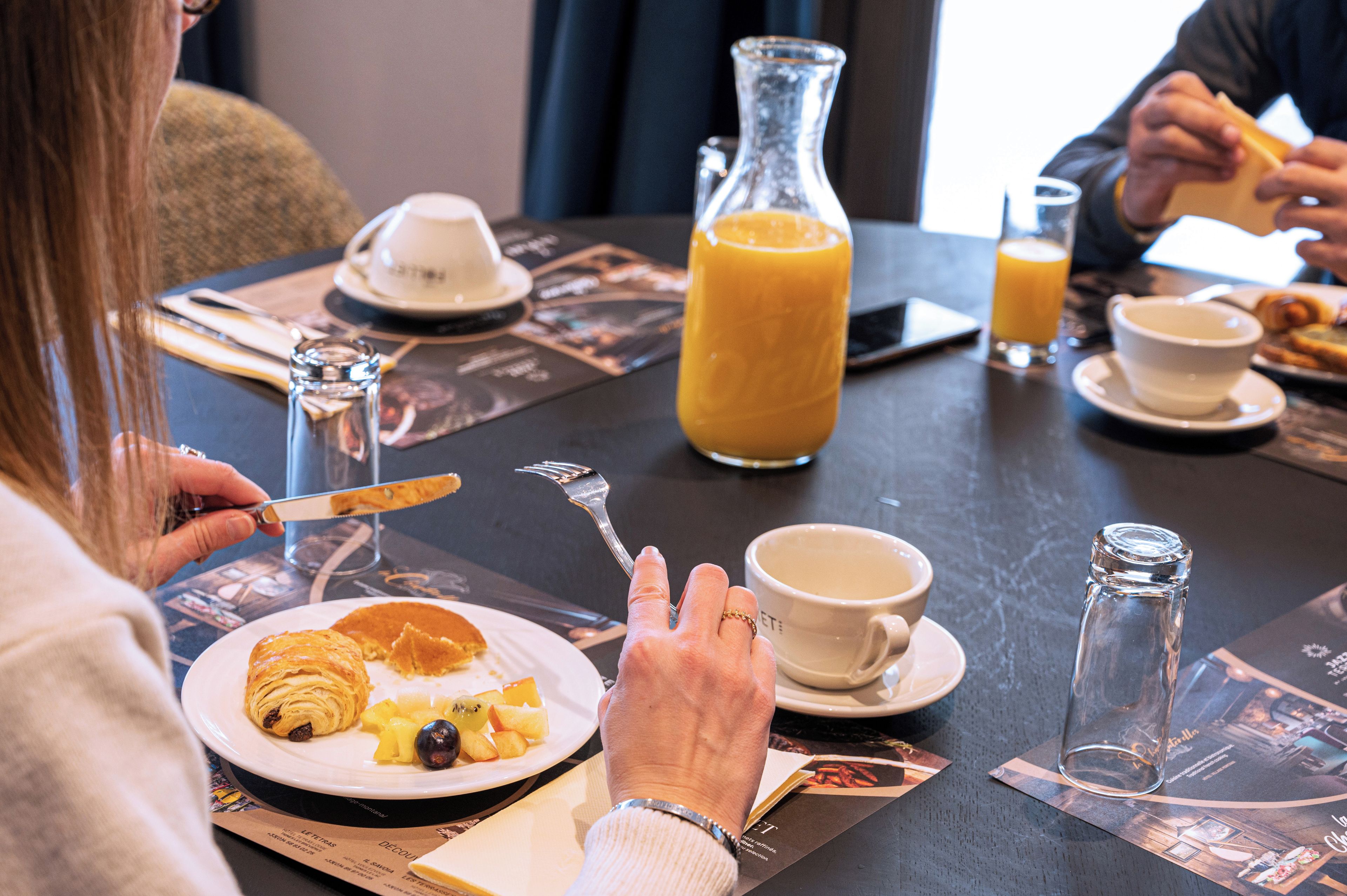 A breakfast setting with a plate of food, a glass of orange juice, and a coffee cup.