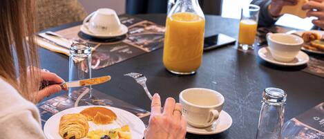 A breakfast setting with a plate of food, a glass of orange juice, and a coffee cup.
