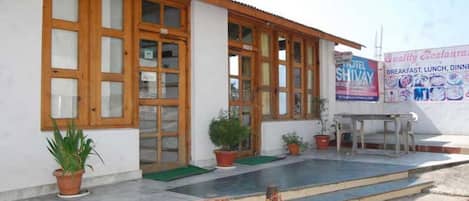 Un edificio con amplios ventanales, una recepción y plantas en macetas.