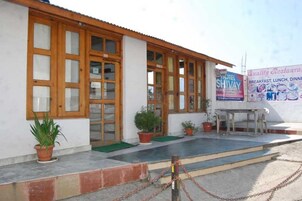 Un edificio con amplios ventanales, una recepción y plantas en macetas.
