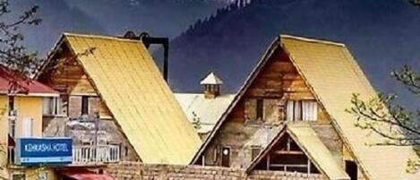 A mountain lodge with a wooden exterior and a sign indicating it is a 'Lodge Hotel.'