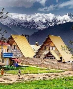 A mountain lodge with a wooden exterior and a sign indicating it is a 'Lodge Hotel.'