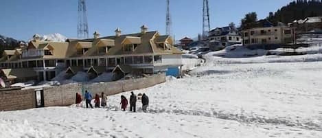 Un hôtel composé de plusieurs bâtiments, avec un sol recouvert de neige et un ciel dégagé.