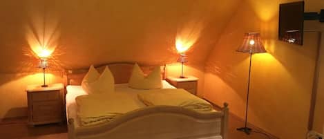 Un dormitorio con una cama, dos mesitas de noche y dos lámparas.